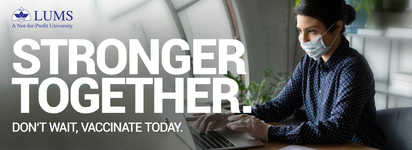 Stronger Together Don't Wait, Vaccinate Today, written in bold white letters on a gray background with a picture of a masked female office employee working on her laptop